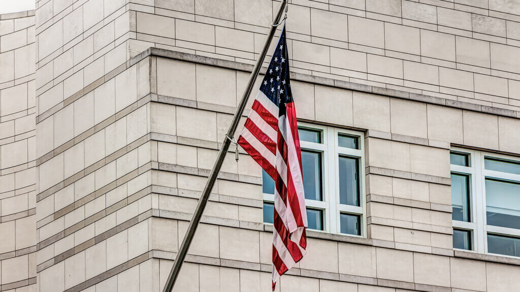 US-Flagge an Gebäude als Symbol für internationales Vertragsrecht in den USA US-Flagge an Gebäude als Symbol für internationales Vertragsrecht in den USA