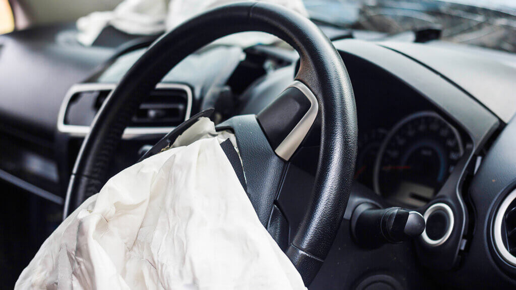 Airbag im Lenkrad nach Autounfall als Symbol für Verkehrsunfälle und Schadensersatz in den USA Airbag im Lenkrad nach Autounfall als Symbol für Verkehrsunfälle und Schadensersatz in den USA